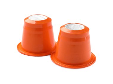 Beyaz üzerine izole edilmiş iki plastik kahve kapsülü.