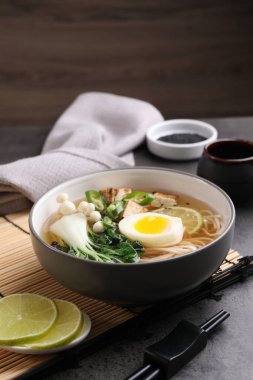 Gri masada servis edilen bir kase vejetaryen ramen.