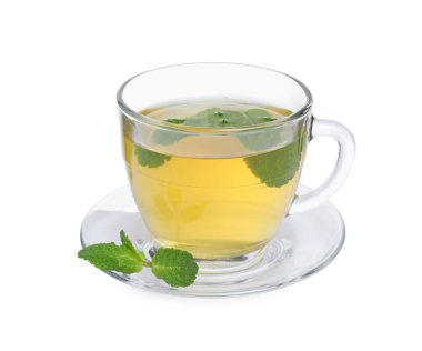 Cam fincanda taze yeşil çay, beyaz üzerinde izole edilmiş nane ve çay tabağı.