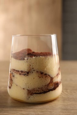 Ahşap masada cam içinde nefis tiramisu, yakın plan.