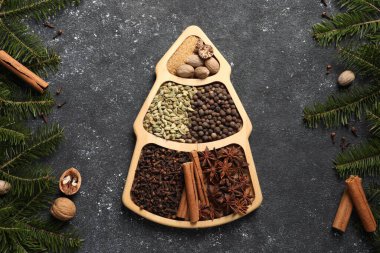 Farklı baharatlar, fındıklar ve köknar dalları koyu gri desenli masa, düz yatıyordu.