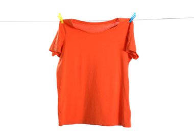 Çamaşır ipinde kurumuş turuncu bir tişört beyaza izole edilmiş.