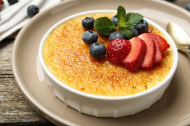 Böğürtlenli ve nane şekerli nefis creme brulee ahşap masada, yakın plan