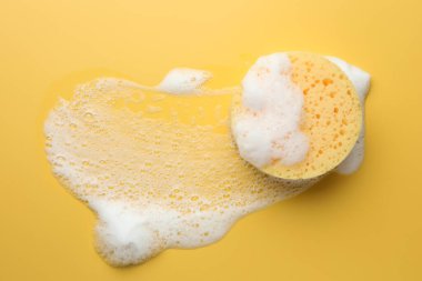 Sarı arka planda köpüklü sünger, üst görünüm