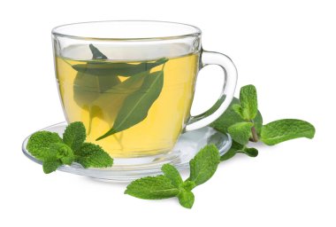 Cam fincanda taze yeşil çay, beyaz üzerinde izole edilmiş nane ve çay tabağı.
