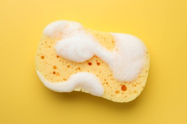 Sarı arka planda köpüklü sünger, üst görünüm