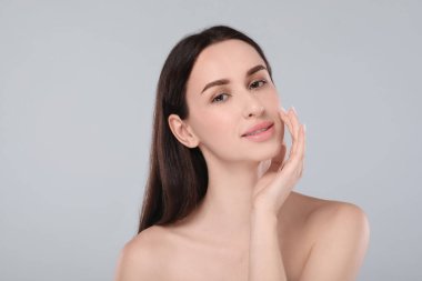 Açık gri arka planda güzel bir genç kadının portresi