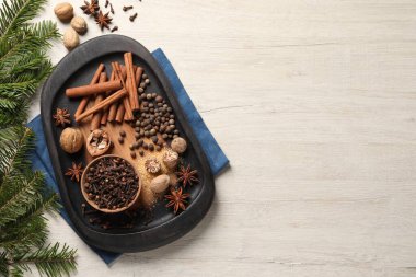 Farklı baharatlar, fındık ve köknar dalları tahta masada, düz yerde. Metin için boşluk