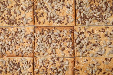 Arka plan olarak keten, ayçiçeği ve susam tohumlu gevrek krakerleri, üst görünüm