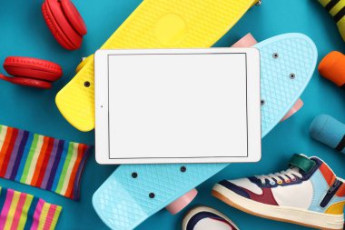 Açık mavi zemin üzerinde modern tablet ile düz kompozisyon yatıyordu. Metin için boşluk