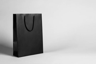 Gri arka planda siyah bir alışveriş çantası. Metin için boşluk