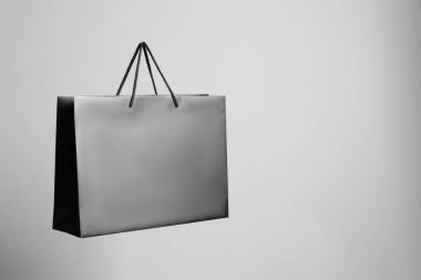 Gri arka planda siyah bir alışveriş çantası. Metin için boşluk