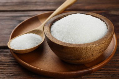 Kase içinde granüle şeker ve tahta masada kaşık, yakın plan.