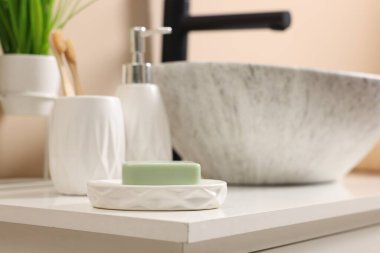 Farklı banyo aksesuarları ve lavabonun yanında kişisel bakım ürünleri.