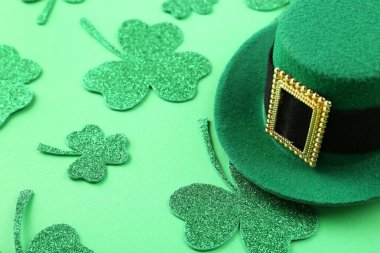 Aziz Patrick Günü. Yeşil arka planda leprikon şapka ve dekoratif yonca yaprakları.