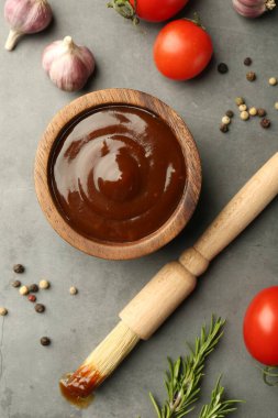 Düz kompozisyon ve lezzetli barbekü sosu gri desenli masada.