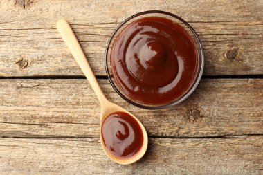 Tabakta leziz barbekü sosu ve ahşap masada kaşık, üst manzara.