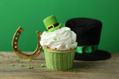 St. Patrick 'in gündüz partisi. Lezzetli kek, leprikon şapka kaplamalı ve ahşap masa üzerinde altın nalı.