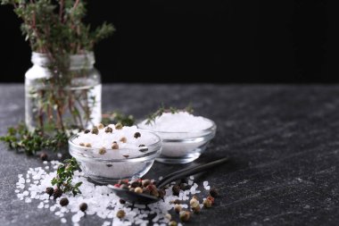 Taze kekikli tuz ve koyu gri desenli masada biber, yakın plan. Metin için boşluk