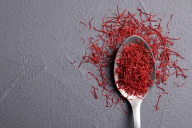 Aromatik safran ve kaşık gri masada, üst manzara. Metin için boşluk