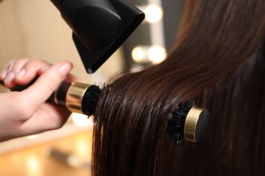 Kuaför kuaför kuaförde müşterinin saçını kurutuyor.