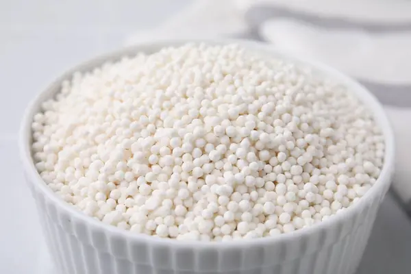 Tapioca pearls in bowl on white table, closeup