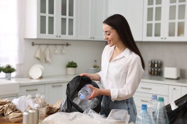 Mutfakta çöpleri ayıran gülümseyen kadın. Metin için boşluk