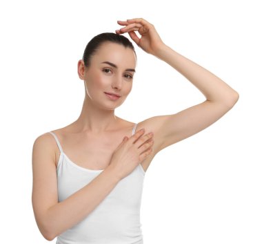 Güzel bir kadın, beyaz arka planda pürüzsüz, temiz bir ciltle koltukaltı gösteriyor.