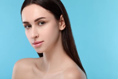 Açık mavi arka planda güzel bir genç kadının portresi. Metin için boşluk