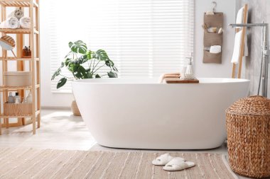 Banyodaki küvette farklı banyo aksesuarları ve sabunlar.