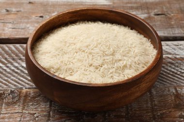 Tabakta çiğ basmati pilavı, ahşap masada, yakın plan.