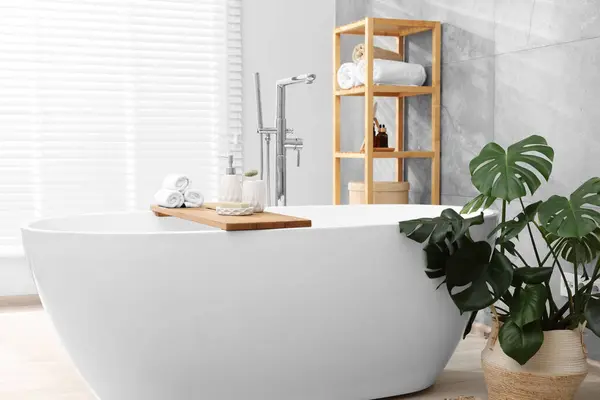 Different personal care products on bath tub in bathroom