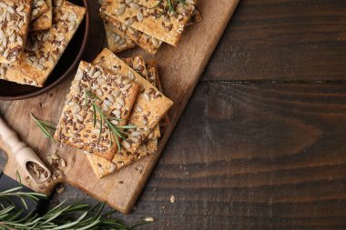 Keten, ayçiçeği, susam tohumu ve ahşap masada biberiyeli gevrek kraker. Metin için boşluk