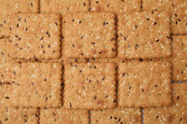 Arka plan olarak keten ve susam tohumlu gevrek krakerleri, üst görünüm