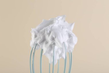 Bej arka planda krem şantili çırpma çırpma, yakın plan.