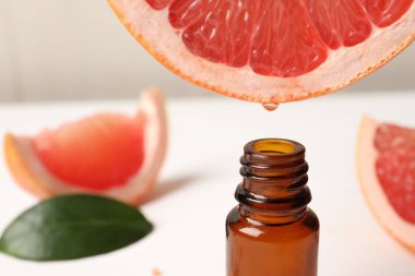 Masada meyve suyundan şişeye greyfurt suyu damlatıyor, yakın plan. Metin için boşluk