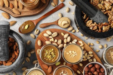 Farklı fıstıklardan fındık ezmesi yapıyorum. Açık gri masa üzerinde düz bileşim yatıyordu