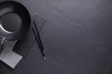 Siyah masada boş demir tava ve çubuklar, üst manzara. Metin için boşluk