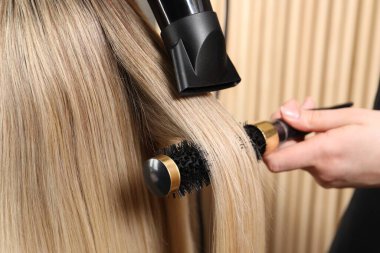 Kuaför kuaför kuaförde müşterinin saçını kurutuyor.