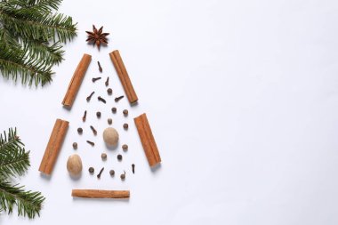 Farklı baharatlardan yapılmış Noel ağacı ve beyaz masa üzerindeki köknar dalları düz. Metin için boşluk