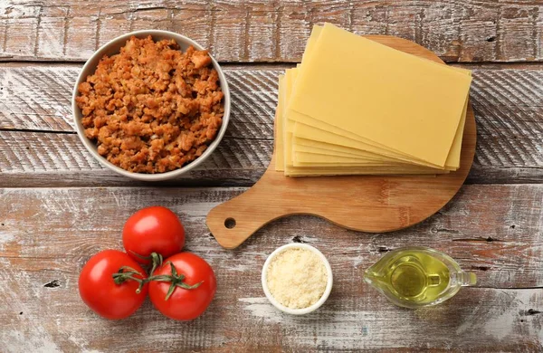 Flat lay composition with products for cooking lasagna on wooden rustic table