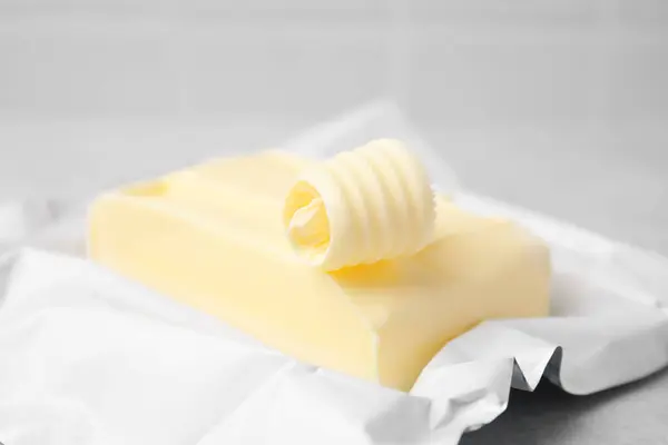 Tasty butter and curl on light grey table, closeup