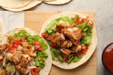 Sebzeli lezzetli tacolar ve gri desenli masa üzerinde et.