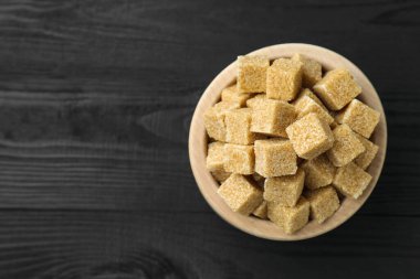 Kahverengi şeker küpleri siyah ahşap masada, üst manzara. Metin için boşluk