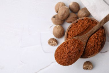 Nutmeg tozu ve tohumlar beyaz masada, düz yerde. Metin için boşluk