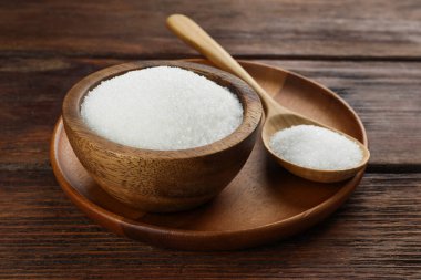 Kase içinde granüle şeker ve tahta masada kaşık, yakın plan.