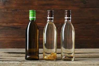 Sebze yağları. Ahşap masada cam şişelerde farklı pişirme yağları.