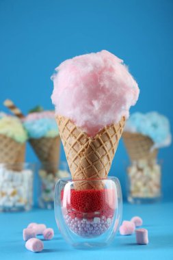 Krep külahında pamuk şeker ve açık mavi arka planda marşmelov. Yakın plan.