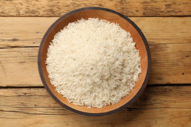 Tabakta çiğ basmati pilavı, ahşap masa, üst manzara.