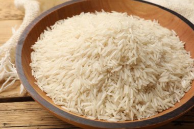 Tabakta çiğ basmati pilavı, ahşap masada, yakın plan.